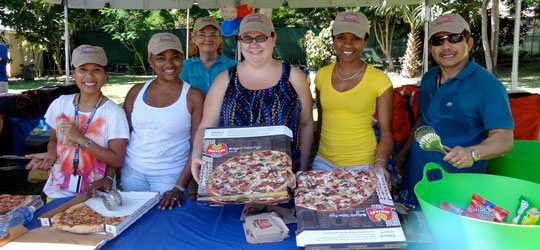 U.S. Embassy volunteers serve delicious pizzas provided courtesy of Marco’s pizza.