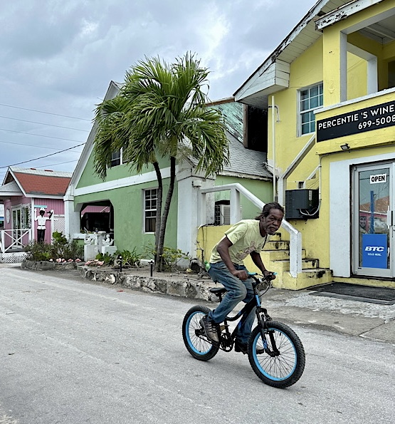 Boy riding bicycle down street in Harbour Island, Bahamas.